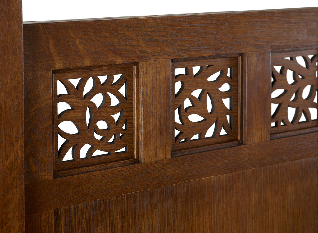 Close-up of a wooden headboard with intricate carvings