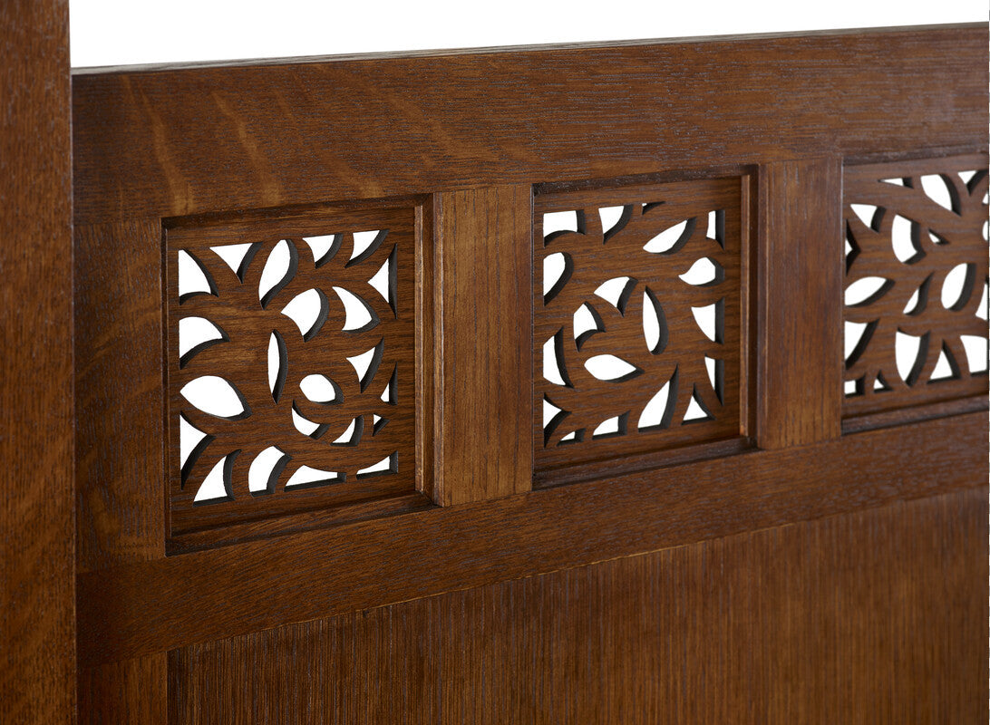 Close-up of a wooden headboard with intricate carvings
