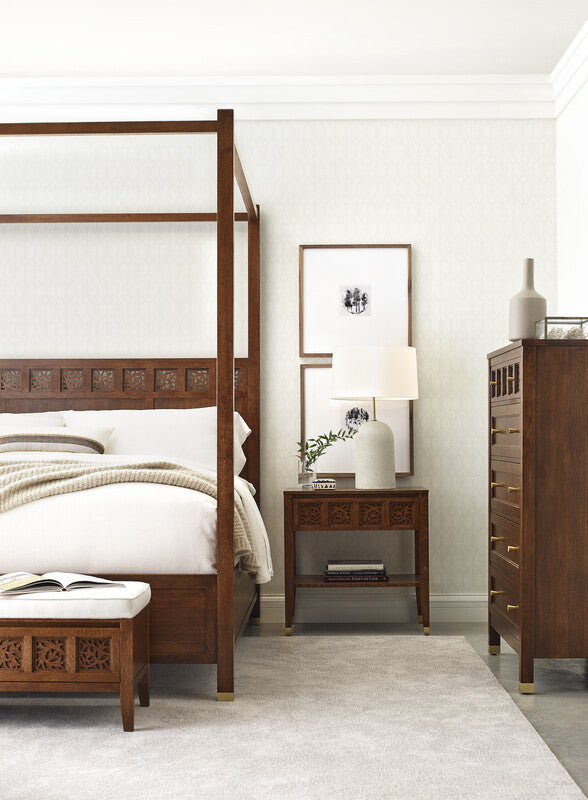 Bedroom with wooden bed, nightstand, and dresser in a well-lit room.