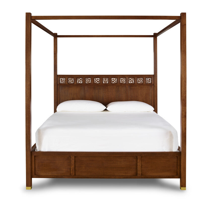 Wooden canopy bed with white bedding on a white background