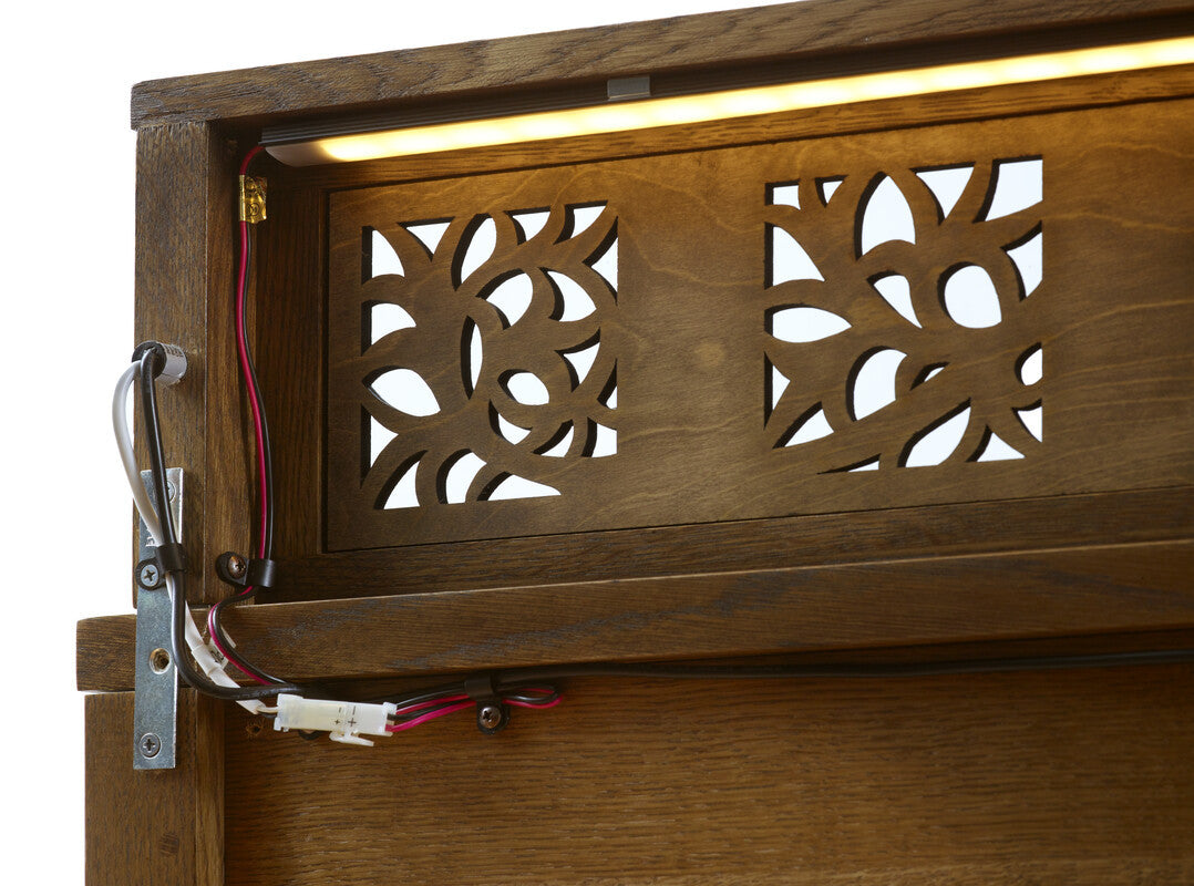 Wooden panel with decorative cut-out design and visible wiring.