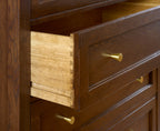 Wooden dresser with open drawer and gold handles