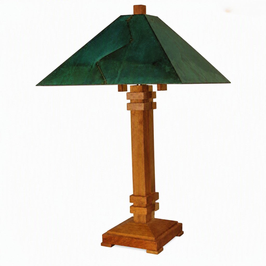 A vintage-style table lamp with a dark green metal conical shade and a warm brown wooden base with geometric block details, shown against a plain white background.