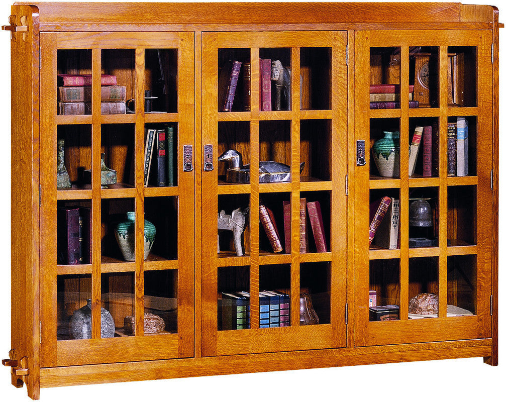Wooden bookshelf with glass doors displaying books and decorative items.