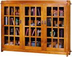 Wooden bookshelf with glass doors displaying books and decorative items.