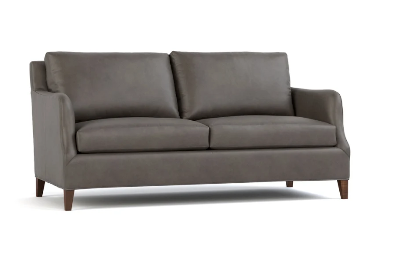 A two-seater loveseat sofa upholstered in dark gray fabric, featuring dark brown wooden legs, shown against a plain white background.