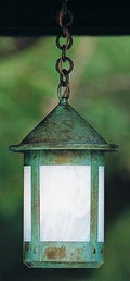 Vintage-style hanging light fixture with green patina on a blurred background