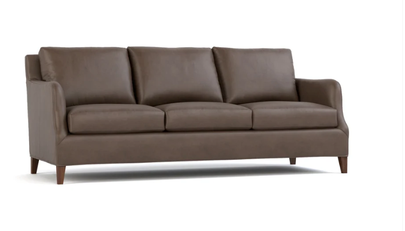 A three-seat sofa upholstered in dark brown leather, shown from a three-quarter angle against a plain white background.