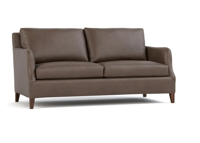 A modern two-seater loveseat sofa upholstered in dark brown leather, featuring dark wood legs, shown against a plain white background.