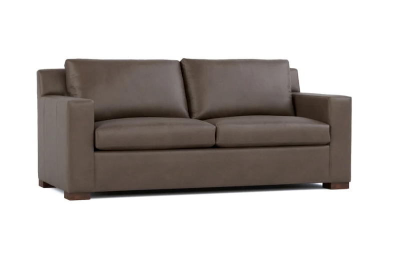 A modern two-seater sofa upholstered in dark brown leather, shown from a three-quarter angle against a plain white background.