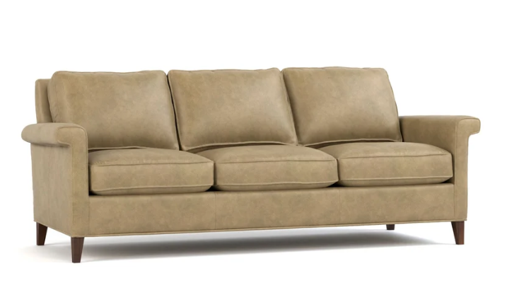 A three-seat upholstered sofa in a warm taupe-beige fabric, featuring dark brown wooden legs, shown against a plain white background.