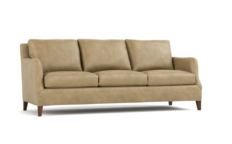 A three-seat upholstered sofa in a warm beige fabric, featuring three back cushions, three seat cushions, rolled arms, and dark brown wooden legs, shown against a plain white background.