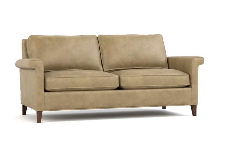 A two-seater loveseat sofa upholstered in a textured tan fabric, featuring dark brown wooden legs, shown against a plain white background.