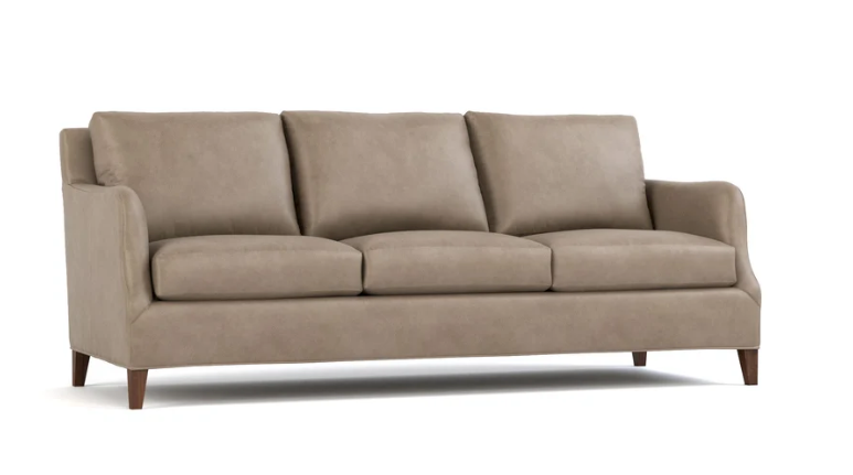 A three-seat upholstered sofa in a taupe beige fabric, featuring dark brown wooden legs, shown against a plain white background.