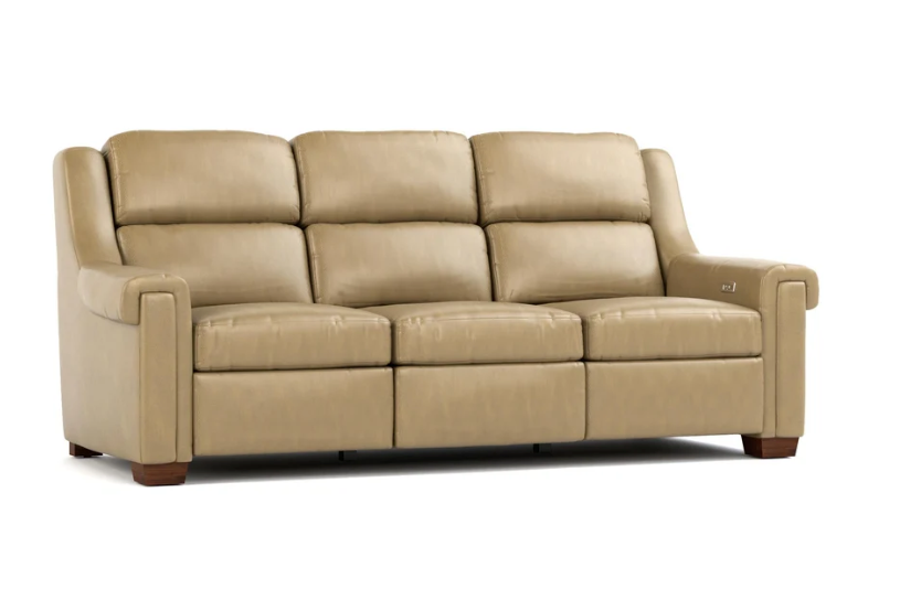 A three-seat power reclining sofa upholstered in light tan leather, shown from a three-quarter angle against a plain white background.