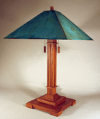 Table lamp with wooden base and teal lampshade on a plain background
