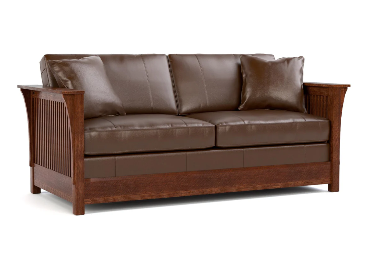 A brown leather loveseat sofa with a wooden frame, featuring slatted side panels and two matching throw pillows, shown against a plain white background.